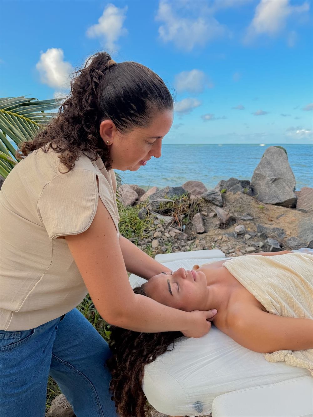 Terapeuta aplicando massagem terapêutica à beira-mar